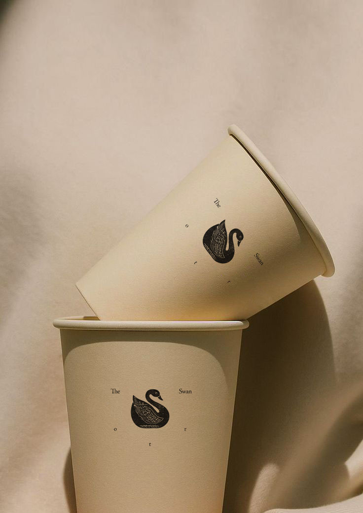 Two paper cups against a white background with a swan logo on it
